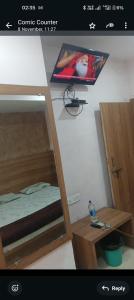 Una imagen de un dormitorio con una litera y un televisor. en Comic hotel, en Raipur