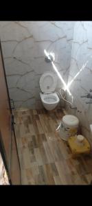 Un baño con inodoro en una pared de piedra. en Comic hotel, en Raipur