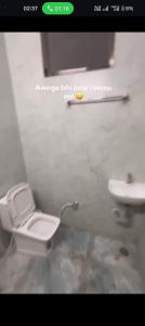 un baño con inodoro y lavabo en Comic hotel, en Raipur