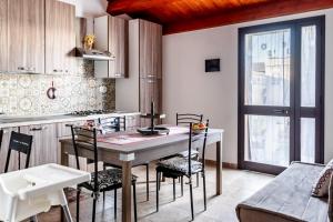 eine Küche mit Tisch und Stühlen in einem Zimmer in der Unterkunft Casuzze I Mori Museum Alloggi di Charme tra Mare Natura e Tradizione Siciliana in Marzamemi