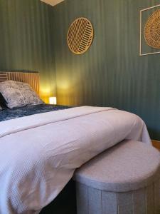 een slaapkamer met een bed met een poef erin bij Au Doubs lac in Malbuisson