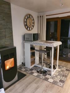 een keuken met een fornuis en een tafel met een open haard bij Au Doubs lac in Malbuisson +24 foto's