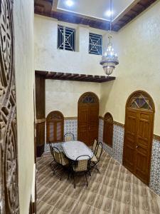 a dining room with a table and a chandelier at Riad al anwar in Rabat +36 photos