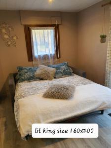 a bedroom with a bed with pillows and a window at Au Doubs lac, Cosy 4 pers Terrasse ,Ski et Nature in Malbuisson