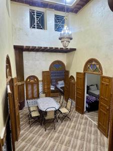 a room with a table and chairs and a bedroom at Riad al anwar in Rabat