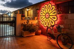 Ein Fahrrad, das neben einer Backsteinmauer mit einem beleuchteten Fenster geparkt ist. in der Unterkunft Casuzze I Mori Museum Alloggi di Charme tra Mare Natura e Tradizione Siciliana in Marzamemi