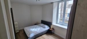 Un dormitorio pequeño con una cama y una ventana. en Appartement proche Grand Parc 1 Chambre, en Mauléon