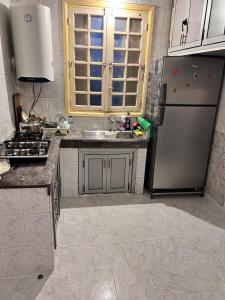 a kitchen with a stainless steel refrigerator and a sink at Tumsilt in Marrakesh