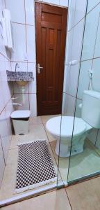 a bathroom with a toilet and a sink and a door at Hospedaria Oliveira - Santo Amaro do Maranhão in Queimada