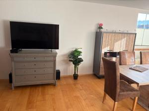 een woonkamer met een tafel en een televisie op een dressoir bij Alpen luaga Ferienwohnung in Sonthofen