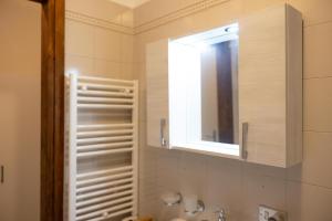 La Piccola Corte nel cuore di Como AC e wifi في كومو: حمام مع حوض ومرآة ونافذة