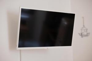 La Piccola Corte nel cuore di Como AC e wifi في كومو: تلفزيون بشاشة مسطحة معلق على حائط أبيض +3 صور