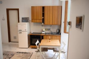 La Piccola Corte nel cuore di Como AC e wifi في كومو: مطبخ صغير مع طاولة وثلاجة