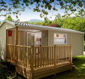 Camping 3 étoiles - Piscine - ccbafeb في Avrillé: كابينة بها شرفة وسطح