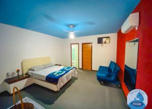 Pousada kite surf 77 في بوزيوس: غرفة نوم بسرير وسقف ازرق