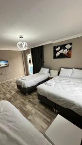 a hotel room with two beds and a tv at Gürleyen Butik Otel in Küçük Çığlı