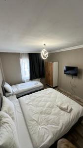 a hotel room with two beds and a flat screen tv at Gürleyen Butik Otel in Küçük Çığlı