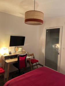 1 dormitorio con escritorio, ordenador y cama en Chez Olivier et Damien, en La Roche-sur-Yon