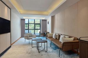 a living room with a couch and a tv at Four Points by Sheraton Anshun, Huangguoshu in Anshun