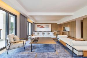 a living room with two beds and a table at Four Points by Sheraton Anshun, Huangguoshu in Anshun +43 photos
