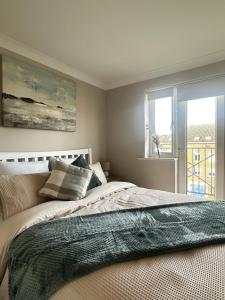 a bedroom with a large bed and a window at Castle View, Cosy Stay in Strood