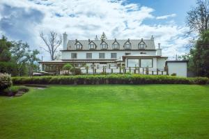 Auberge Willow Inn في Hudson: منزل أبيض كبير مع حديقة أمامه