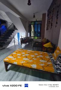 a bedroom with a bed with a yellow blanket at Pink Floyd in Pushkar