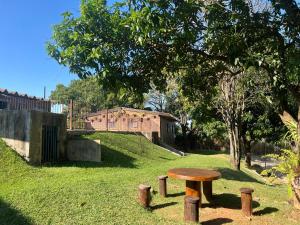 een houten bank in het gras bij een boom bij Chácara Santa Edwiges in Campinas
