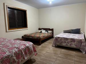 een kamer met 2 bedden en een raam erin bij Chácara Santa Edwiges in Campinas +7 foto's