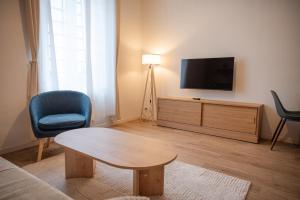 a living room with a table and a tv at Saint-Fons centre appartement meublé in Saint-Fons