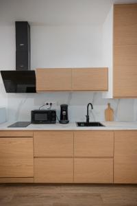 a kitchen with wooden cabinets and a sink at Saint-Fons centre appartement meublé in Saint-Fons +6 photos