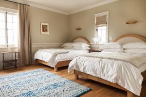 Auberge Willow Inn في Hudson: غرفة نوم بسريرين وسجادة زرقاء