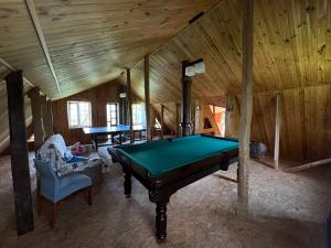 a pool table in a room with a wooden ceiling at Яблунева садиба in Demidovka