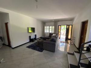 un soggiorno con un divano e una TV di Villa Soleil a Diani Beach