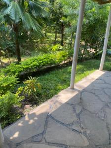 una passerella di pietra con un palo nell'erba di Villa Soleil a Diani Beach