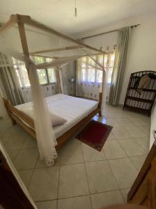 una camera da letto con un letto a baldacchino in una stanza di Villa Soleil a Diani Beach Altre 9 foto