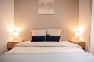 a bedroom with a bed with two lamps on either side at Saint-Fons centre appartement meublé in Saint-Fons