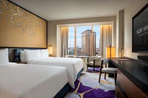 een hotelkamer met twee bedden en een televisie bij Nobu New Orleans, A Caesars Destination in New Orleans