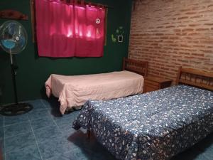 een kamer met 2 bedden en een rood raam bij Casa Miramar in Miramar