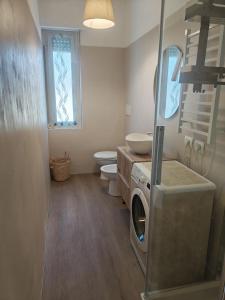 a bathroom with a washing machine and a toilet at Terrazza Groane in Garbagnate Milanese +30 photos