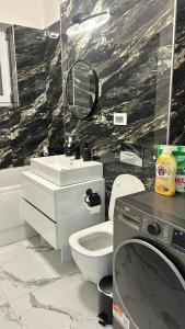 a bathroom with a toilet and a sink and a mirror at Luxury Apartment private parking in Craiova