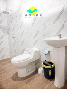 un baño con inodoro y lavabo en Amaru Lodge, en Tingo María