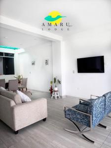 Una sala de estar con un sofá y un televisor. en Amaru Lodge, en Tingo María