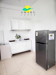 cocina con nevera y encimera con letrero en Amaru Lodge, en Tingo María