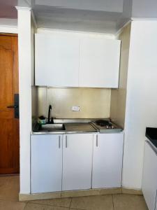 a kitchen with white cabinets and a sink at Vacaciones en el Caribe - Laguito Cartagena al lado de bocagrande in Cartagena de Indias