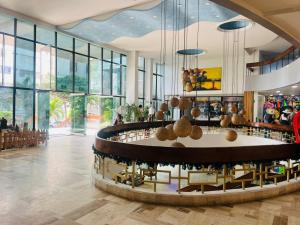 a lobby with a table and chairs and windows at Vacaciones en el Caribe - Laguito Cartagena al lado de bocagrande in Cartagena de Indias +1 photo