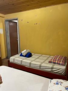 a bedroom with a bed and a yellow wall at Chácara São Marcos in Ibiúna