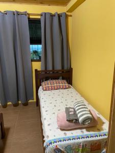 a small bed in a room with a window at Chácara São Marcos in Ibiúna