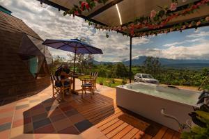 a man sitting at a table on a deck next to a hot tub at Prana Hills in Arbeláez