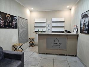 a living room with a reception desk and a couch at Lethabo Guesthouse in Ga-Mankopane